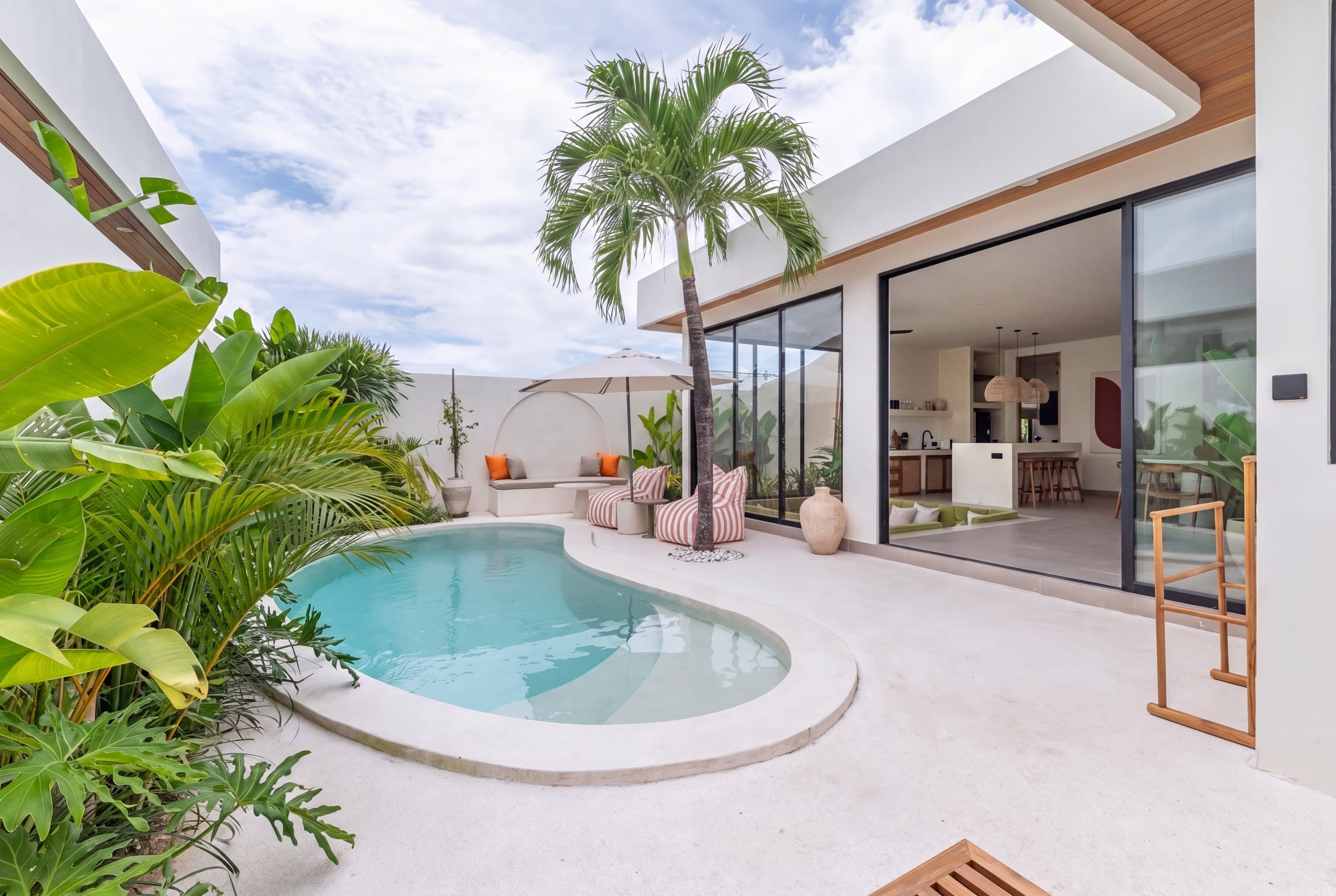 Pool, palm and open-plan living area at Villa Bayu Sari